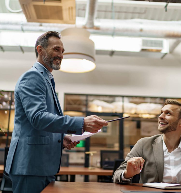 mature-business-coach-or-speaker-make-flip-chart-presentation-to-diverse-businesspeople-at-meeting.jpg